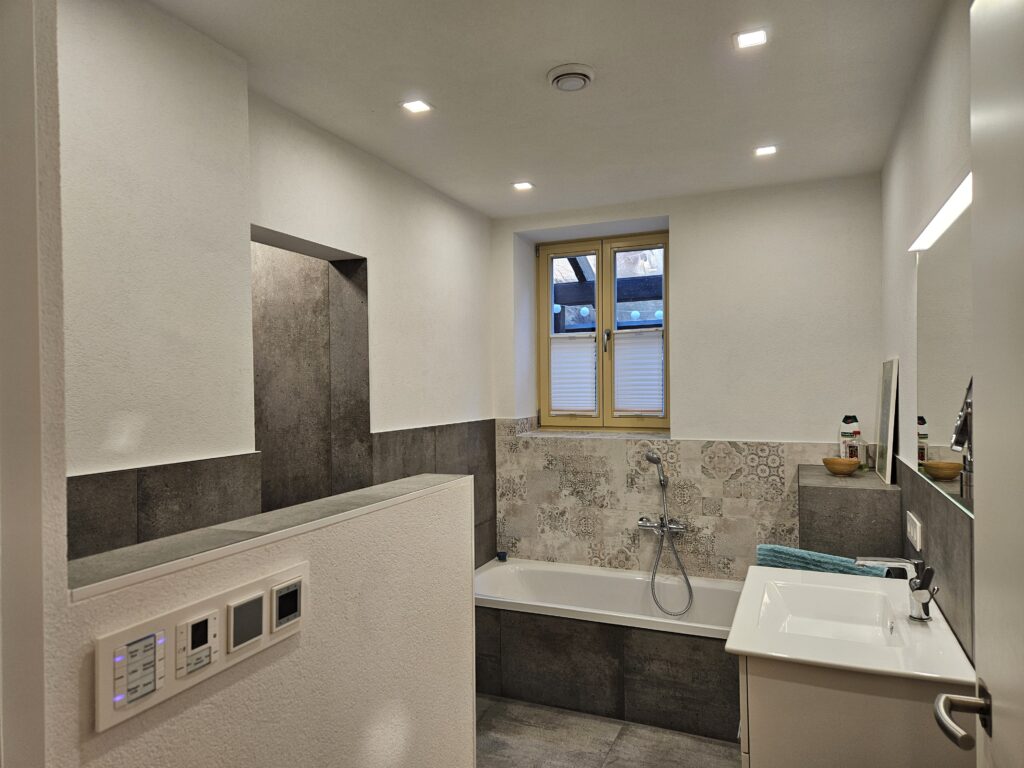 Modernes Badezimmer mit  Fussbodenheizung sowie Badewanne und Regendusche